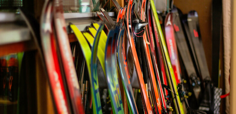 Verschiedene Ski stehen nebeneinander angelehnt an einen Ständer.