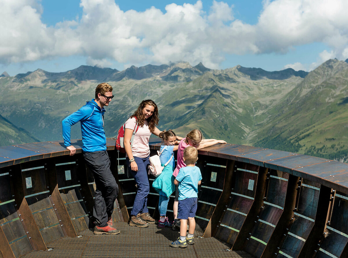 Eine Familie genießt den Ausblick beim Wassermythos Ochsenlacke St. Jakob Brunnalm