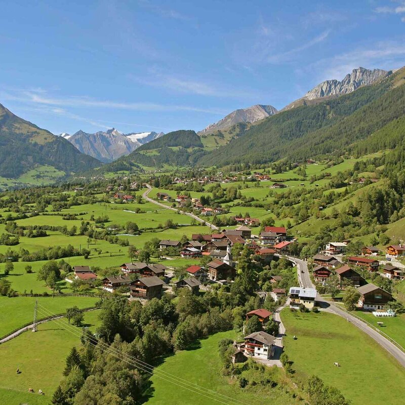 Die Gemeinde Virgen im Sommer umgeben von grünen Wiesen und Wäldern.