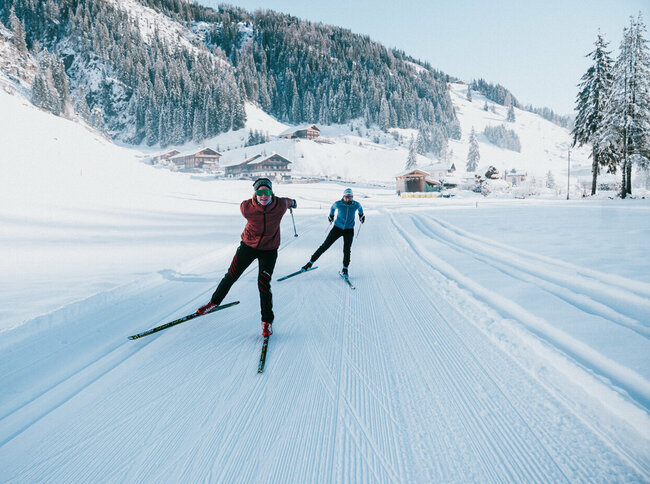 Zwei Langläufer:innen in Action auf der gespurten Loipe in Innervillgraten