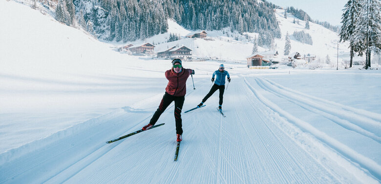 Zwei Langläufer:innen in Action auf der gespurten Loipe in Innervillgraten