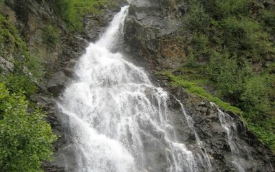 Der Glauritwasserfall in Hopfgarten i. D., der sich seinen Weg durch die grünen Hänge gebahnt hat.